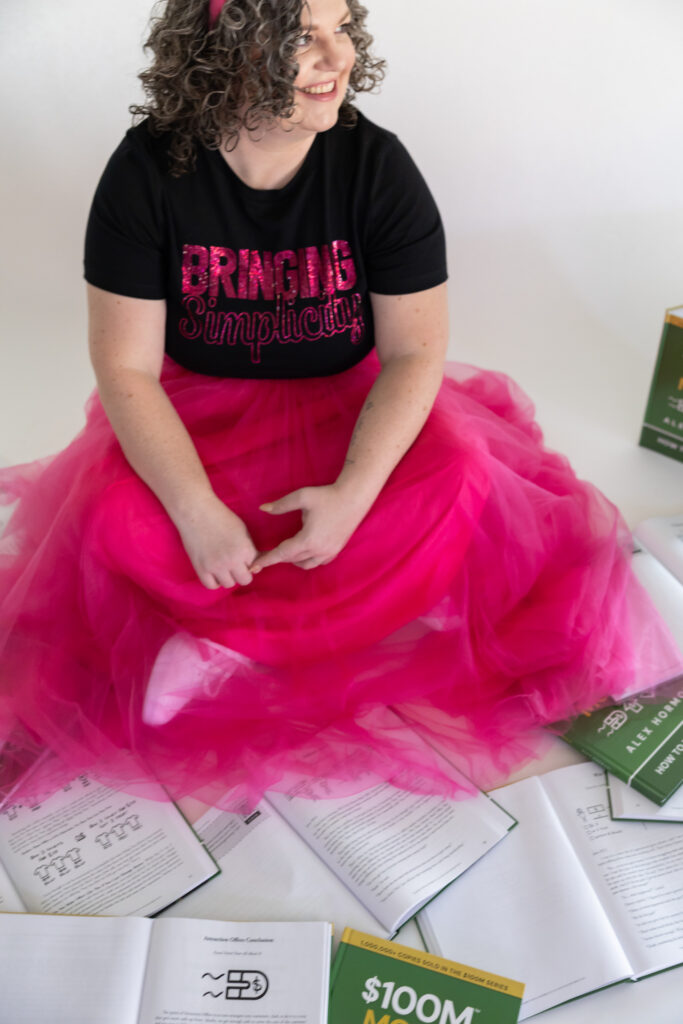 $100mill leads Alex Hormozi, sitting with books